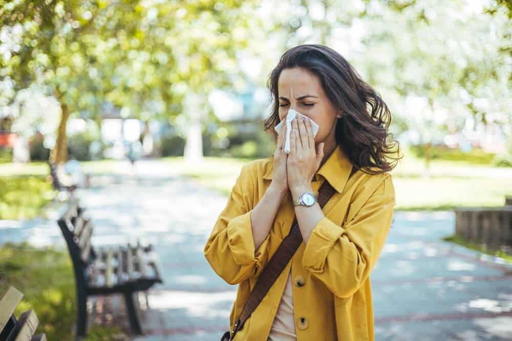 Women sneezing from allergies